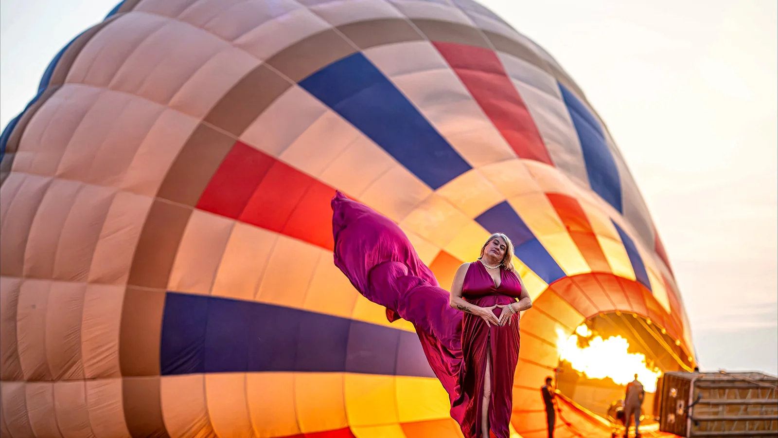 A balloon being inflated beside a lit burner at the launch site