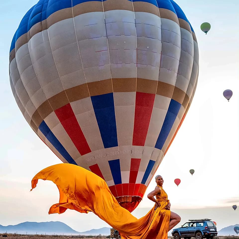 A balloon at the launch site with fabric in the foreground and other balloons in the sky